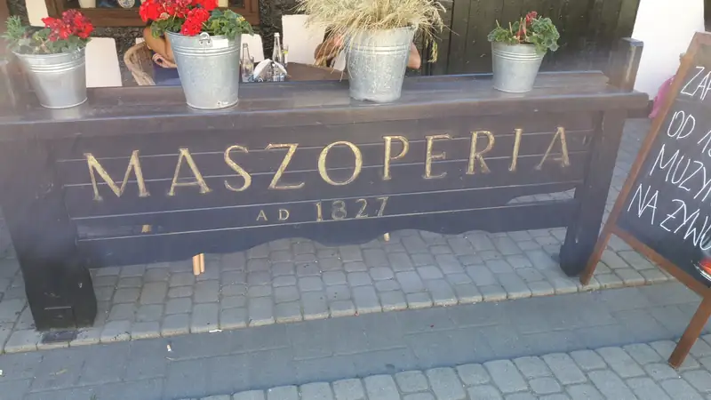 Drewniana skrzynia na kwiaty z wyrytym napisem Maszoperia AD 1827